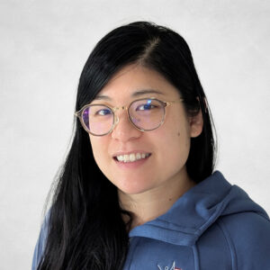 A woman wearing glasses and a blue jacket.